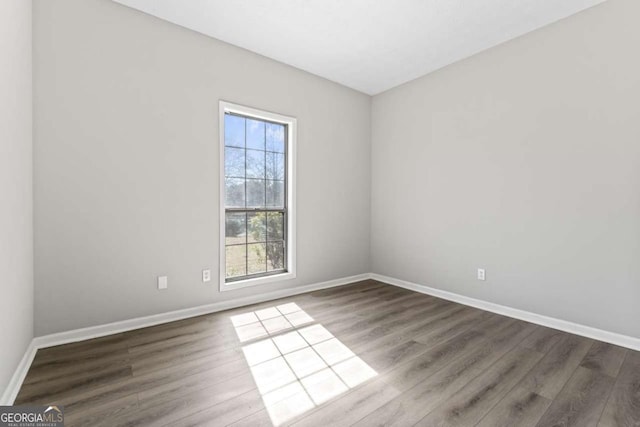 empty room with wood finished floors and baseboards