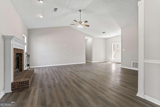 unfurnished living room with dark wood finished floors, visible vents, a fireplace, and a textured ceiling