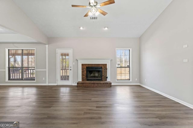 unfurnished living room with vaulted ceiling, a fireplace, dark wood-style floors, and visible vents