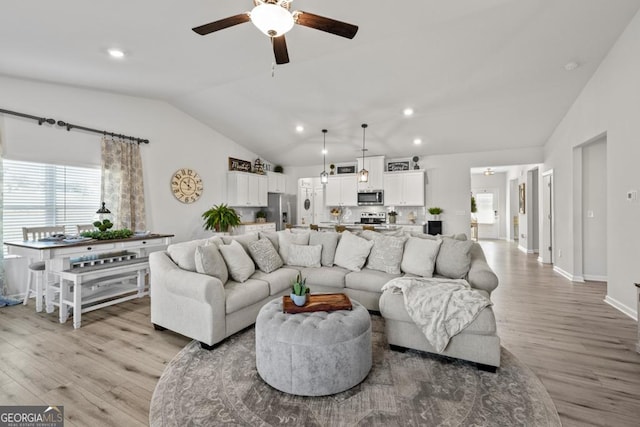 living room featuring light wood-style flooring, ceiling fan, lofted ceiling, and recessed lighting