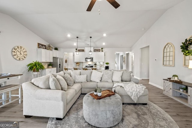 living area with baseboards, a ceiling fan, lofted ceiling, wood finished floors, and recessed lighting