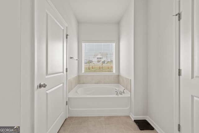 bathroom with a garden tub and tile patterned floors