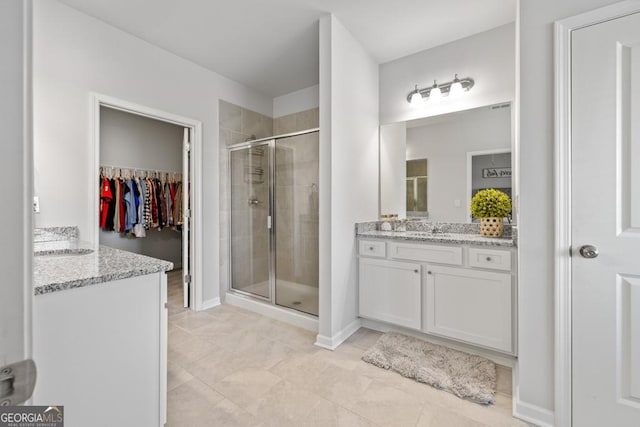 bathroom with baseboards, vanity, and a shower stall