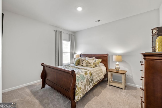 bedroom featuring visible vents, baseboards, and light colored carpet