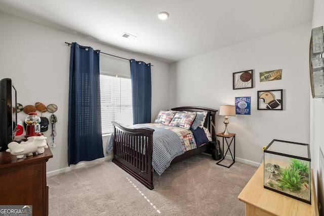 bedroom with baseboards, visible vents, and light colored carpet