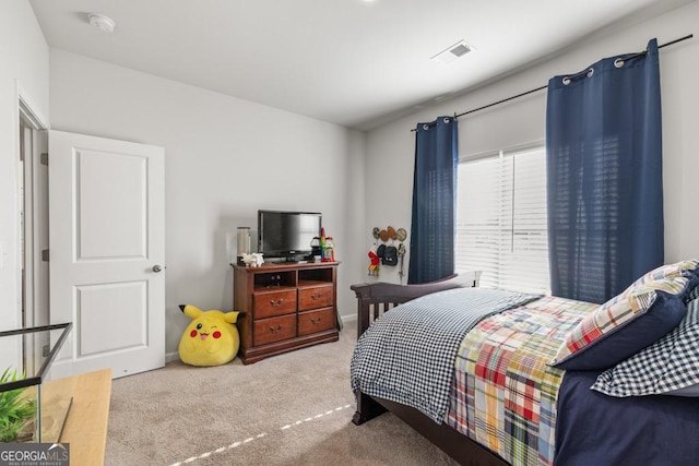 bedroom featuring visible vents and light colored carpet