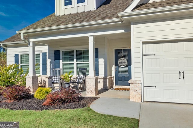 view of exterior entry featuring a garage, covered porch, a shingled roof, and board and batten siding