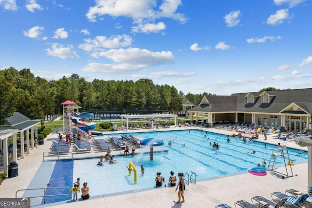 community pool with a water slide and a patio