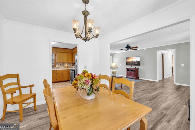 dining room featuring baseboards, ceiling fan with notable chandelier, light wood-style flooring, and crown molding