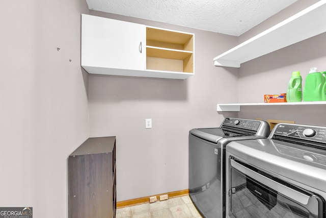 clothes washing area with a textured ceiling, laundry area, washing machine and dryer, and baseboards