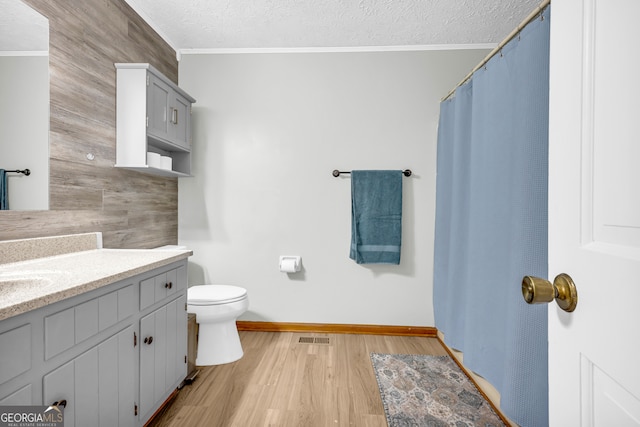 full bathroom with visible vents, ornamental molding, a textured ceiling, and wood finished floors