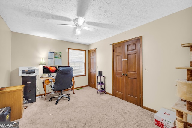 office area featuring a textured ceiling, carpet, a ceiling fan, and baseboards