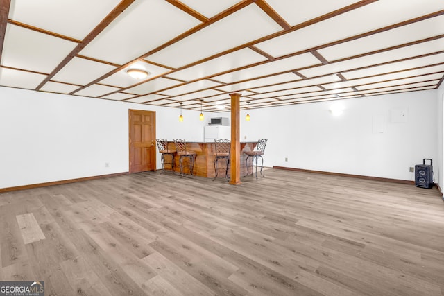 interior space with a dry bar, baseboards, and wood finished floors