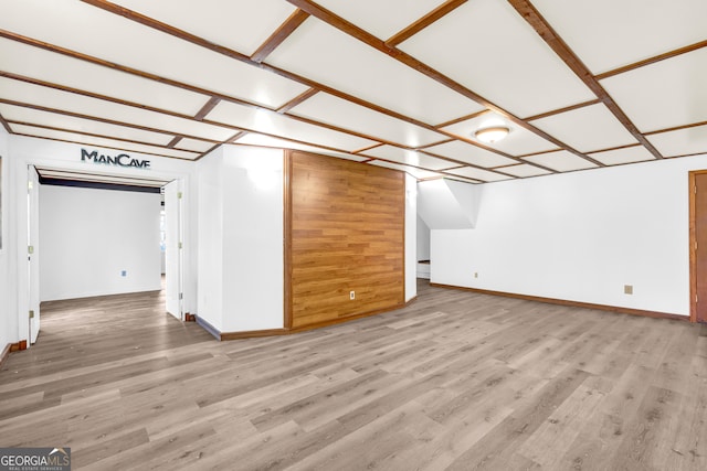 additional living space with baseboards and wood finished floors