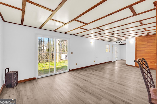 unfurnished living room featuring wood finished floors and baseboards