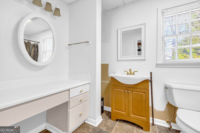 full bathroom featuring a paneled ceiling, baseboards, toilet, and vanity