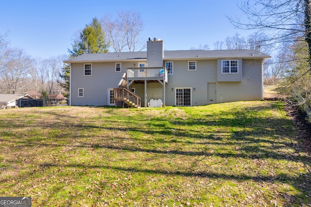 back of property featuring a yard, a chimney, a wooden deck, and stairs