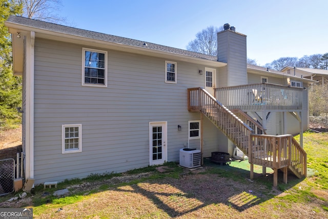 back of property featuring central AC unit, a lawn, a chimney, stairs, and a wooden deck