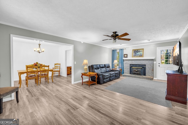 living area with crown molding, a textured ceiling, and wood finished floors