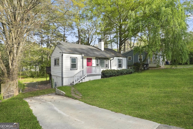 view of front of property featuring a chimney, a front yard, and fence