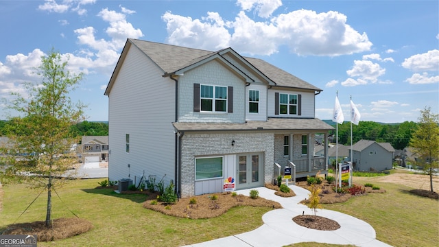 view of front of home featuring driveway, brick siding, a front yard, and french doors