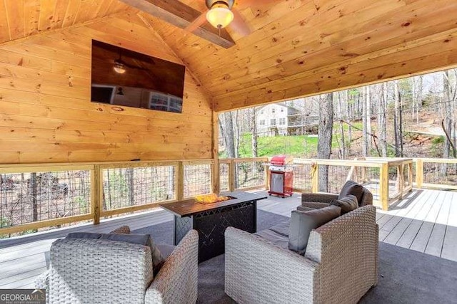 sunroom featuring a ceiling fan, wooden ceiling, and vaulted ceiling