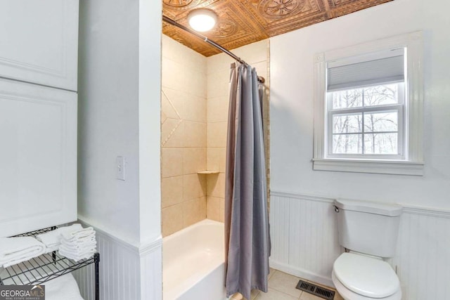 bathroom featuring wainscoting, visible vents, toilet, and tile patterned floors