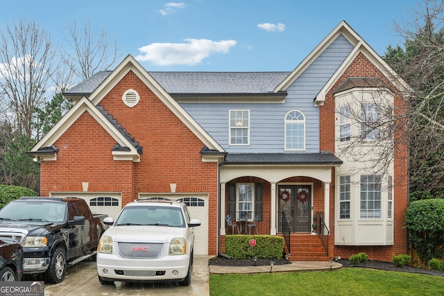 traditional home with driveway, an attached garage, a front yard, and brick siding