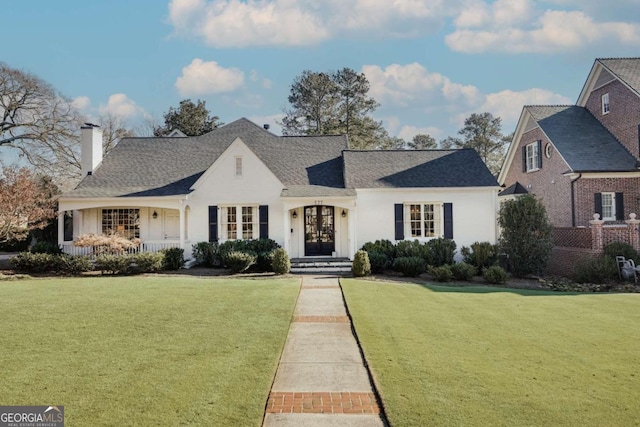 view of front of house featuring roof with shingles and a front yard