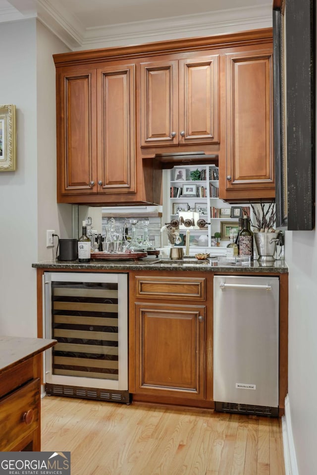 bar with a dry bar, light wood finished floors, beverage cooler, and crown molding