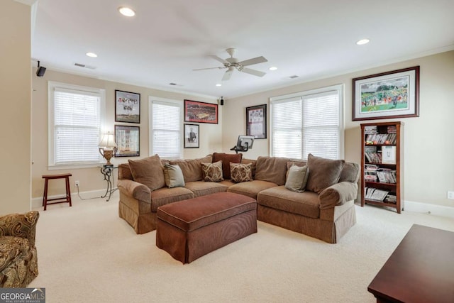 living area featuring light carpet, a healthy amount of sunlight, visible vents, and crown molding