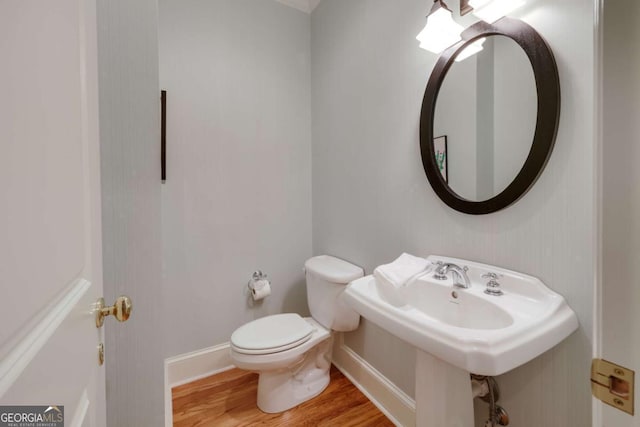 bathroom featuring baseboards, toilet, and wood finished floors