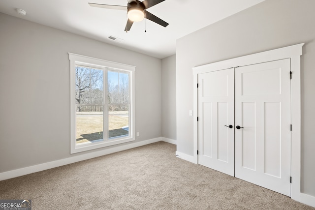 unfurnished bedroom with a ceiling fan, a closet, carpet flooring, and baseboards