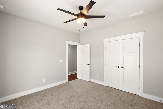 unfurnished bedroom with ceiling fan, visible vents, baseboards, a closet, and carpet