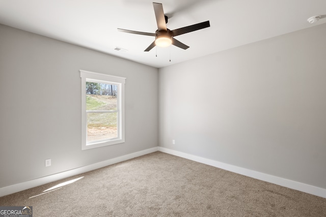 carpeted empty room featuring visible vents, ceiling fan, and baseboards