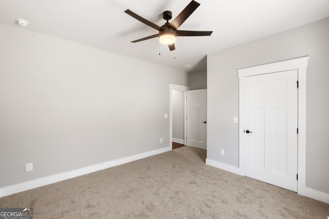 unfurnished bedroom featuring carpet, a ceiling fan, and baseboards