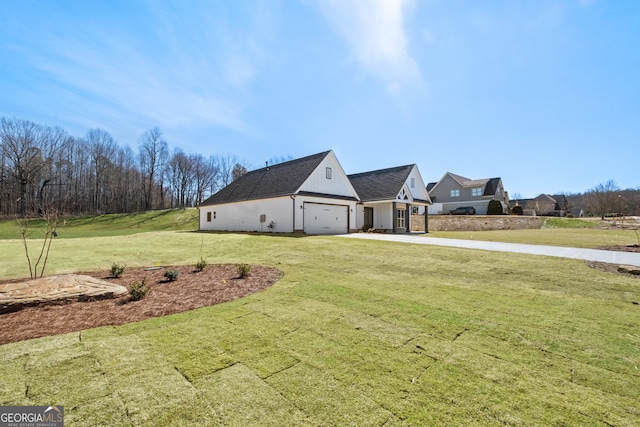 view of home's exterior with board and batten siding, concrete driveway, and a yard