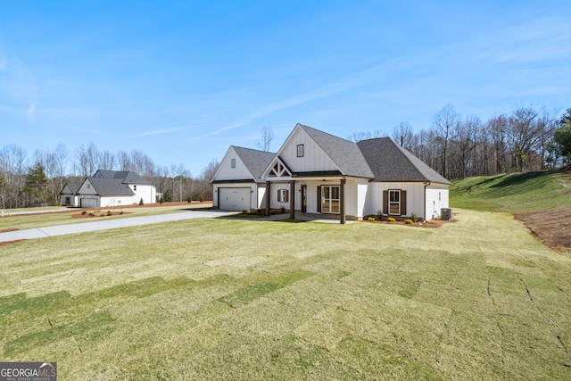 view of front facade with a garage, driveway, roof with shingles, a front lawn, and board and batten siding