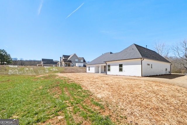 back of property featuring roof with shingles