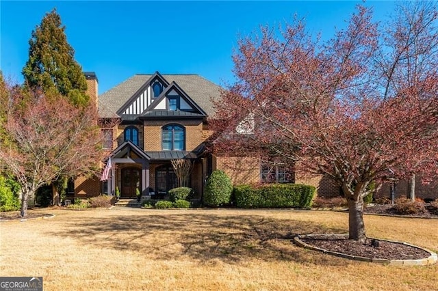 view of front facade featuring a front yard and brick siding