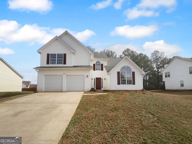 traditional home with a garage, concrete driveway, and a front yard