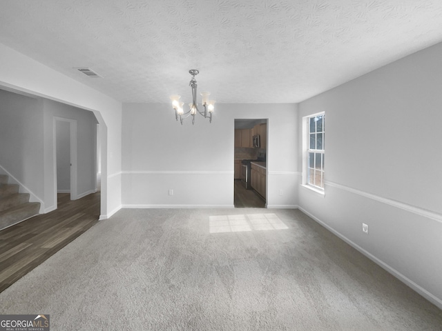 interior space featuring visible vents, an inviting chandelier, a textured ceiling, baseboards, and stairs