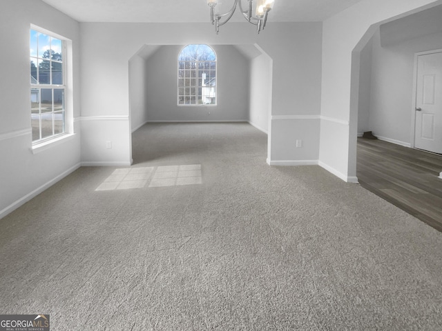 bonus room with baseboards, carpet, and an inviting chandelier