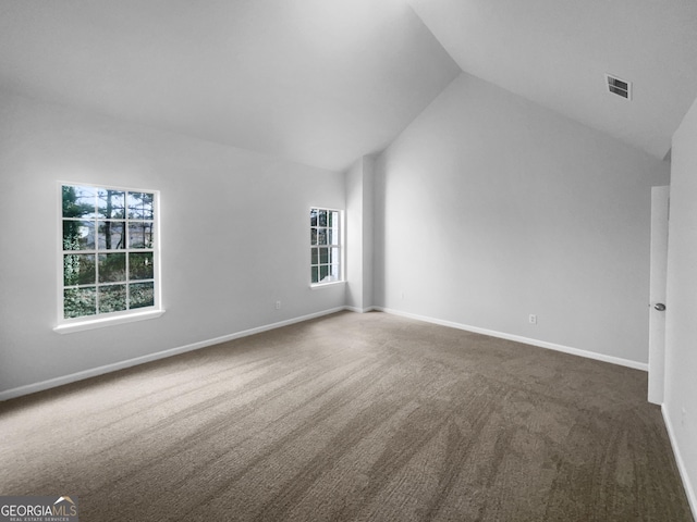 interior space featuring high vaulted ceiling, visible vents, dark carpet, and baseboards