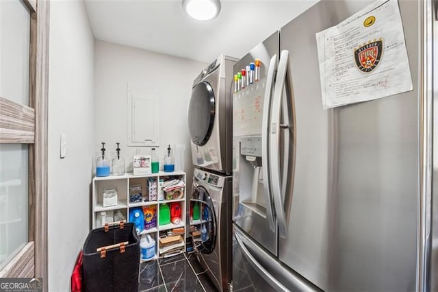 clothes washing area featuring stacked washer and dryer and laundry area