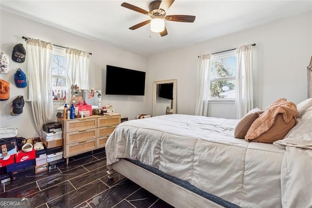 bedroom featuring multiple windows and a ceiling fan