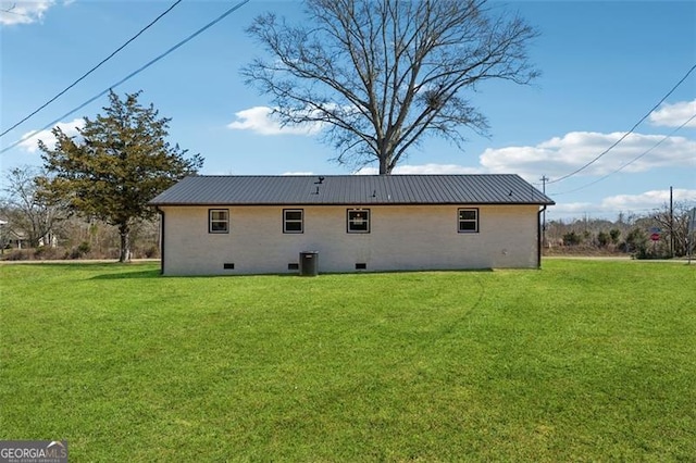 back of property featuring metal roof, crawl space, a lawn, and central air condition unit