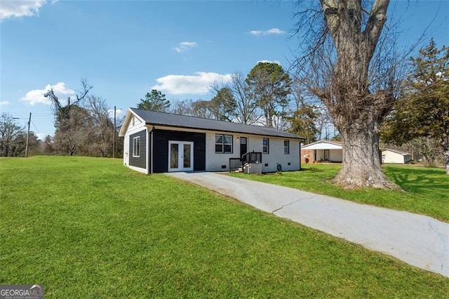 view of front of property featuring french doors, a front yard, crawl space, metal roof, and driveway