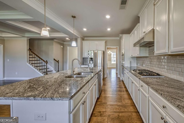 kitchen featuring a spacious island, appliances with stainless steel finishes, hanging light fixtures, under cabinet range hood, and a sink