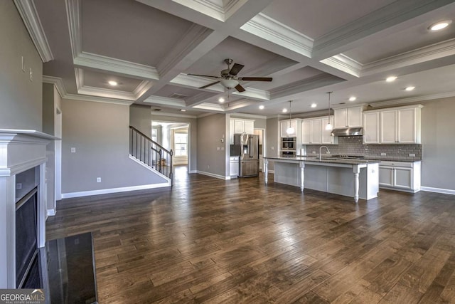 kitchen with an island with sink, open floor plan, stainless steel refrigerator with ice dispenser, and decorative light fixtures